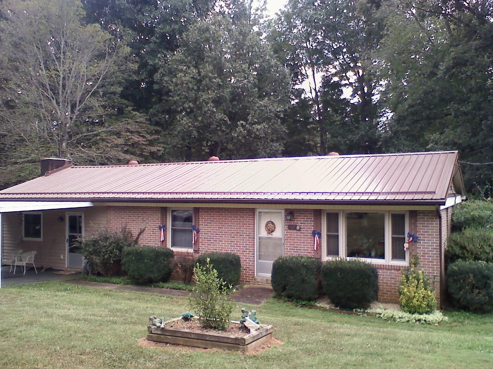 Bronze metal roof on a brick ranch home with a carport in Dayton